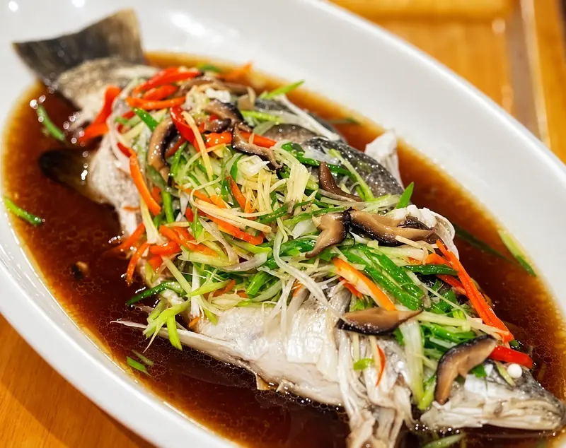 ปลาในน้ำซอส โรยสมุนไพรซอยและพริกที่ครัวบ้านวัง