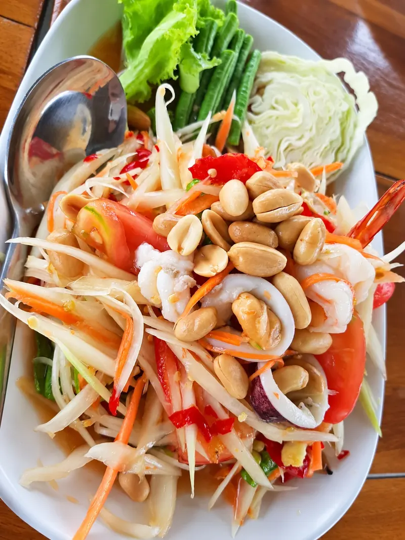 ส้มตำทะเลใส่กุ้ง ปลาหมึก ถั่วลิสง และมะเขือเทศที่ครัวบ้านวัง